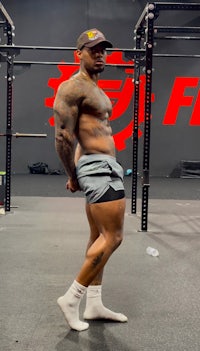 a man posing in front of a barbell in a gym